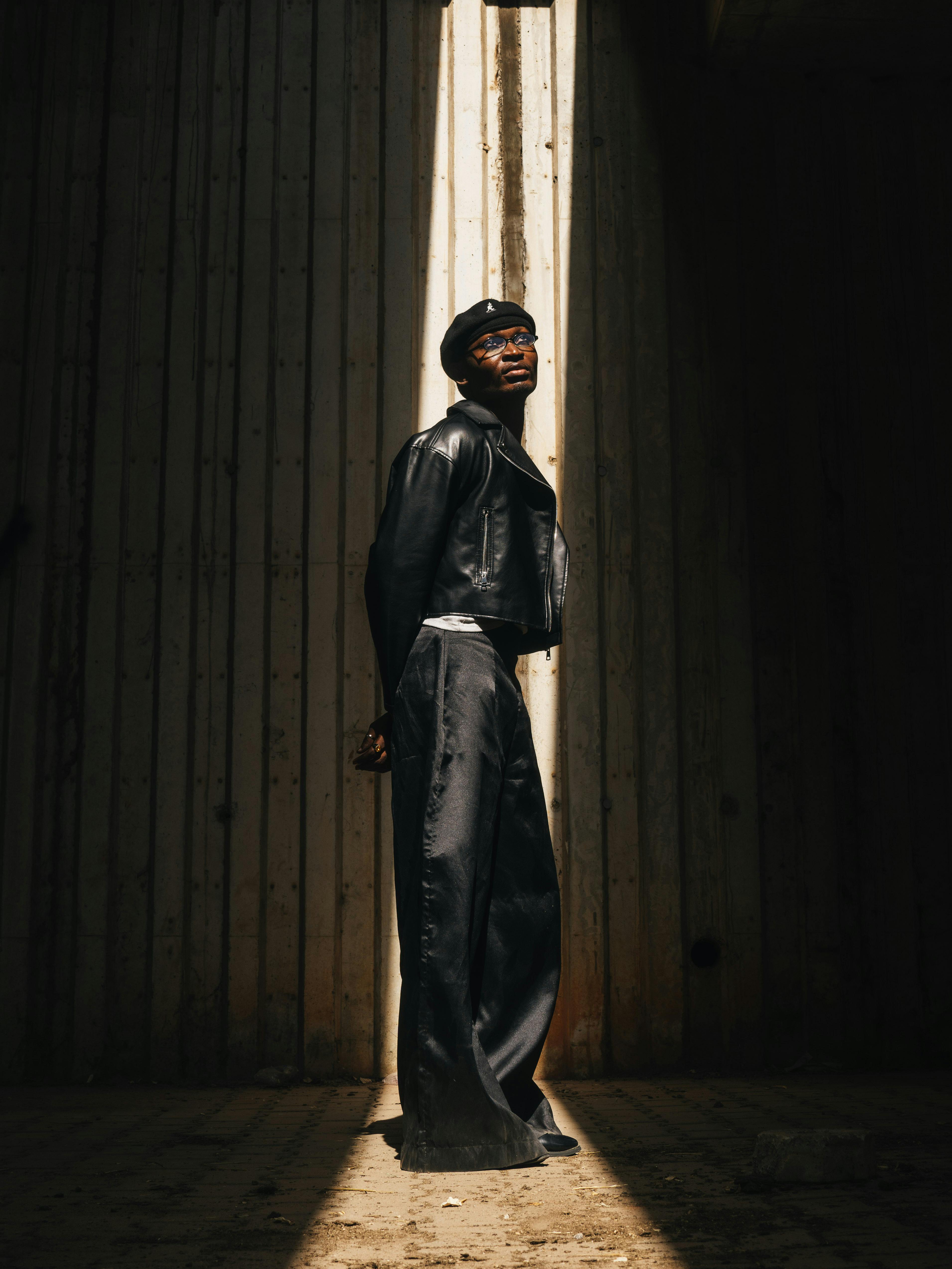 免費 一位時尚人士在都市陽光下擺出極具戲劇性的姿勢，投射出強烈的藝術光影。 圖庫相片