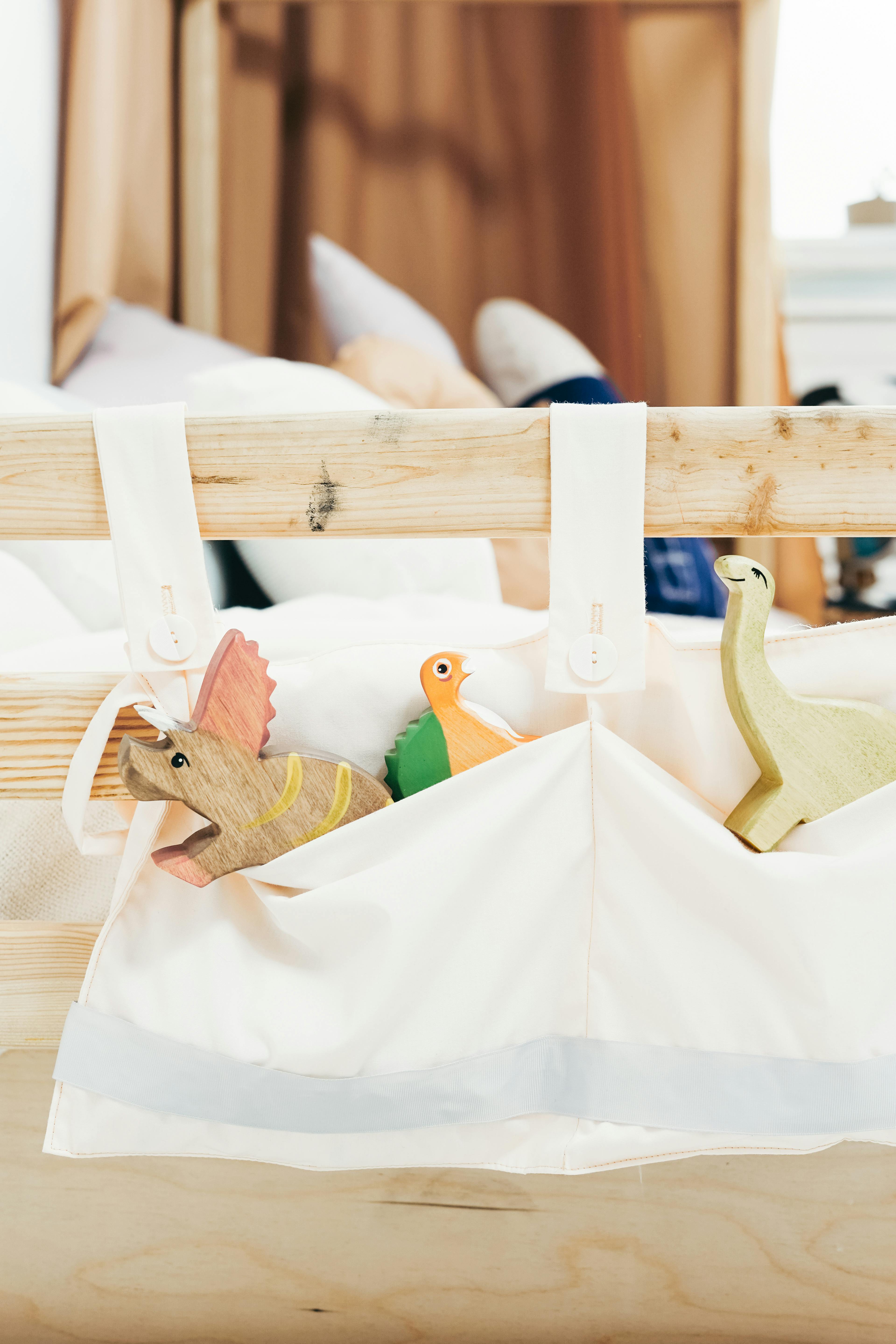 white cloth bag with brown wooden toy figurines