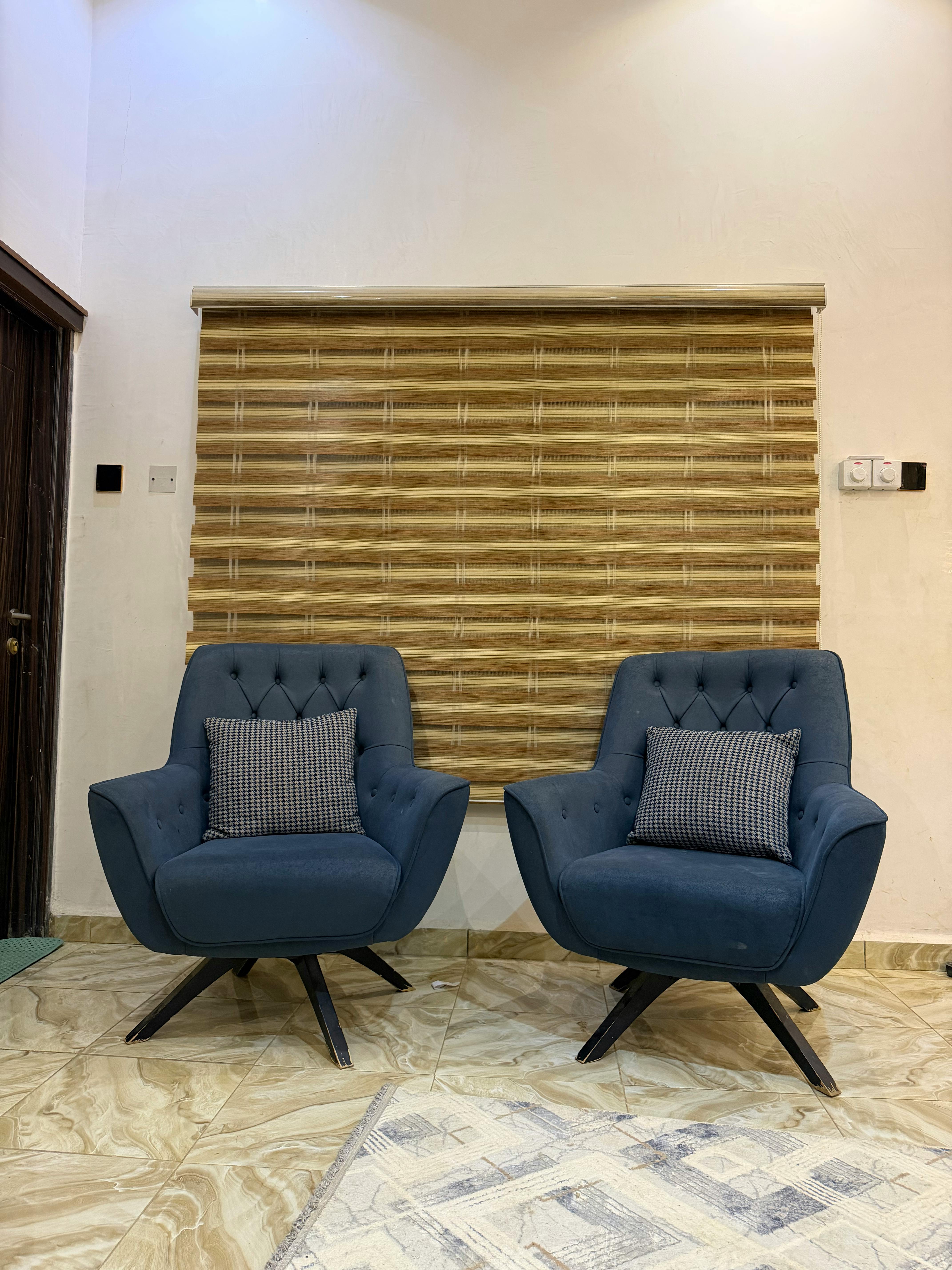 Zadarmo Elegantné modré kreslá s vankúšmi v modernom interiéri s drevenými žalúziami. Fotka z fotobanky