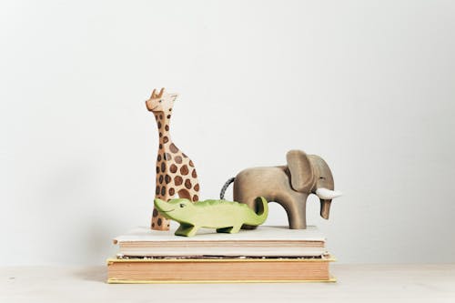 Фигурка коричневого и зеленого жирафа на книге