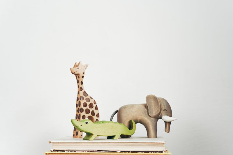 Wooden giraffe, elephant and crocodile toys in a row
