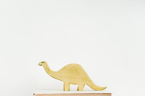 Brown Wooden Dinosaur on Book