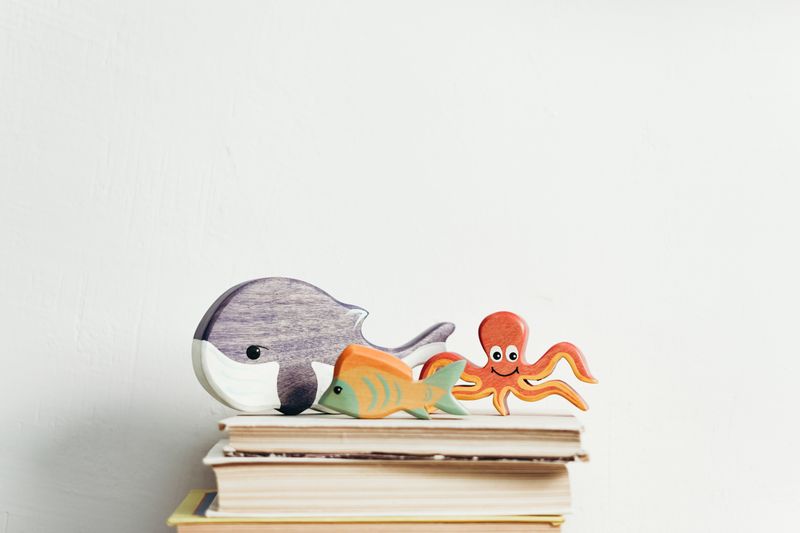 Wooden whale and octopus toys standing on picture books