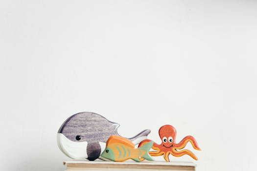 迷人的木制海洋生物玩具系列，以白色背景为特色，并展示了鲸鱼、鱼和章鱼等元素