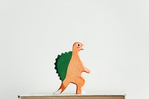 Зеленая и коричневая деревянная фигурка динозавра