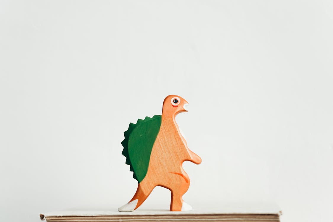 Free Green and Brown Wooden Dinosaur Figurine Stock Photo
