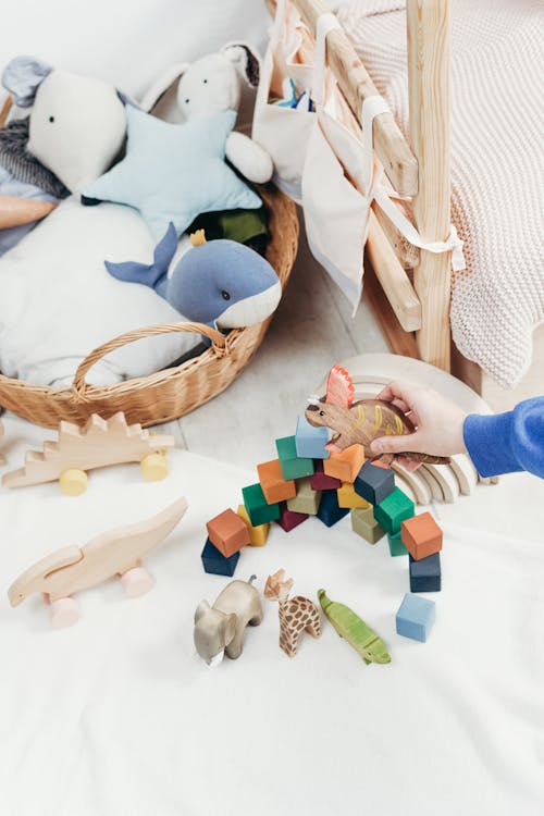 Free Child's Hand Holding a Wooden Toy Stock Photo