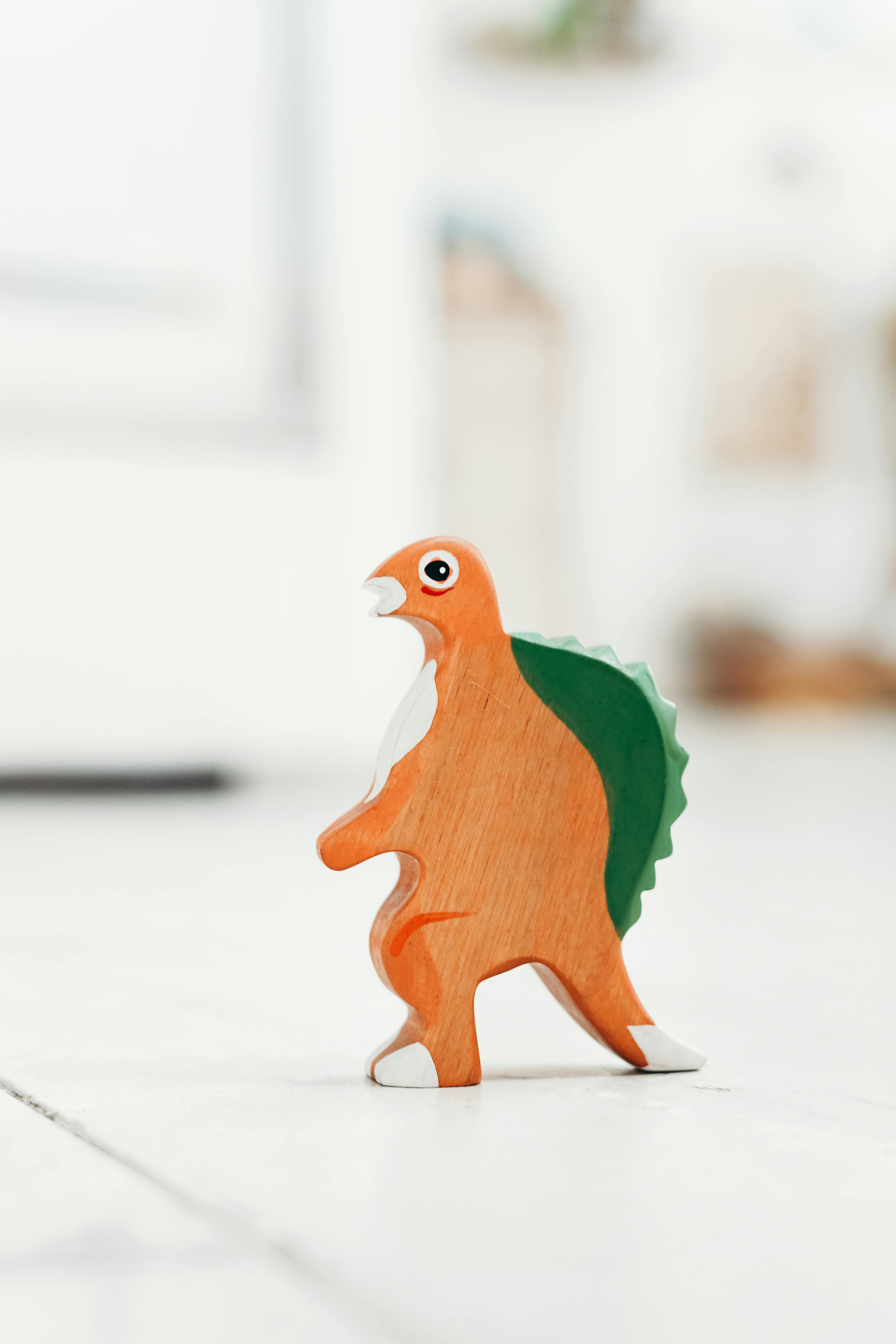 orange and green wooden dinosaur toy