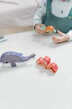 一个孩子在游戏室的桌子上，正与充满活力的木制玩具动物互动，尽显创造力和乐趣