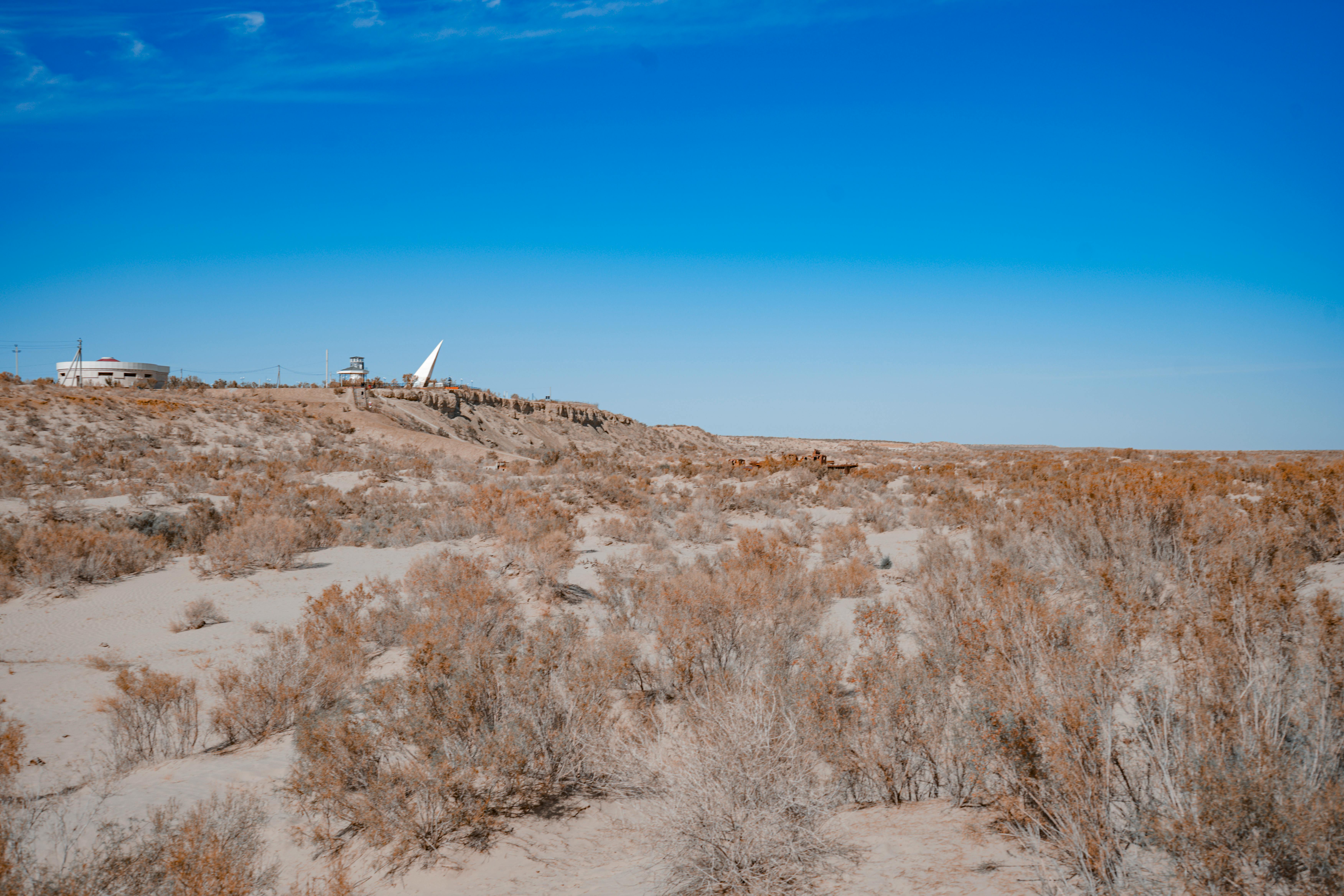 무료 무이나크의 황량한 풍경은 건조한 지형과 버려진 건물로 이루어져 있으며, 생태계 파괴를 여실히 보여줍니다. 스톡 사진