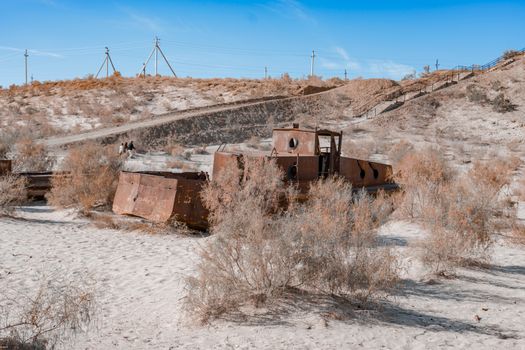 Rusted shipwreck in the desert sands of the Aral Sea in Uzbekistan, illustrating ecological decline.