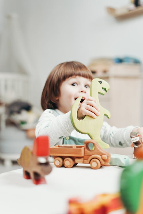 Fille En Haut à Manches Longues Blanc Jouant Avec Des Jouets