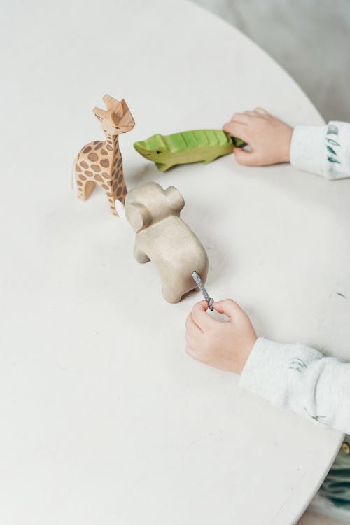 Enfant Tenant Des Jouets Animaux En Bois