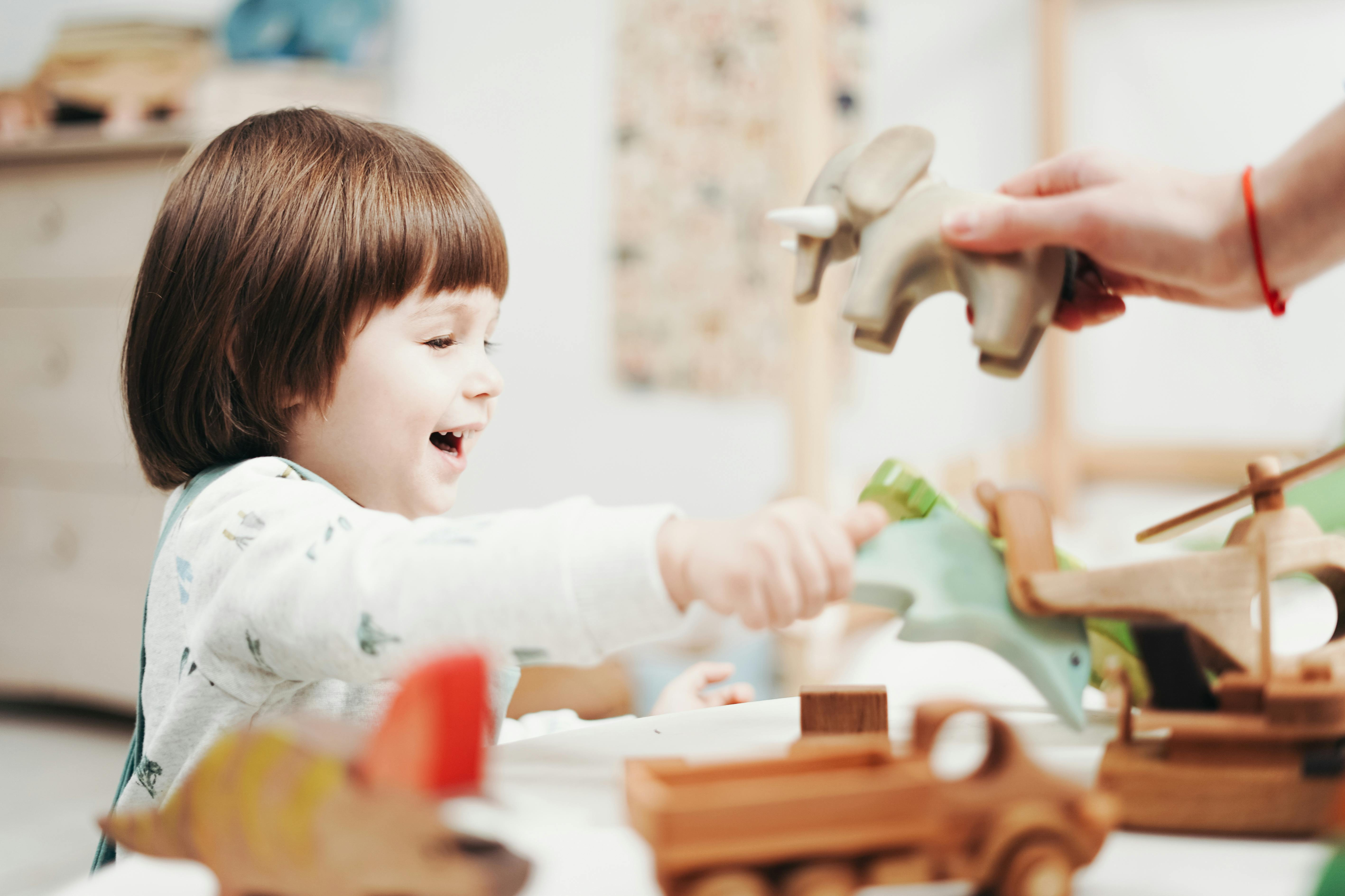 child playing with green plastic toy