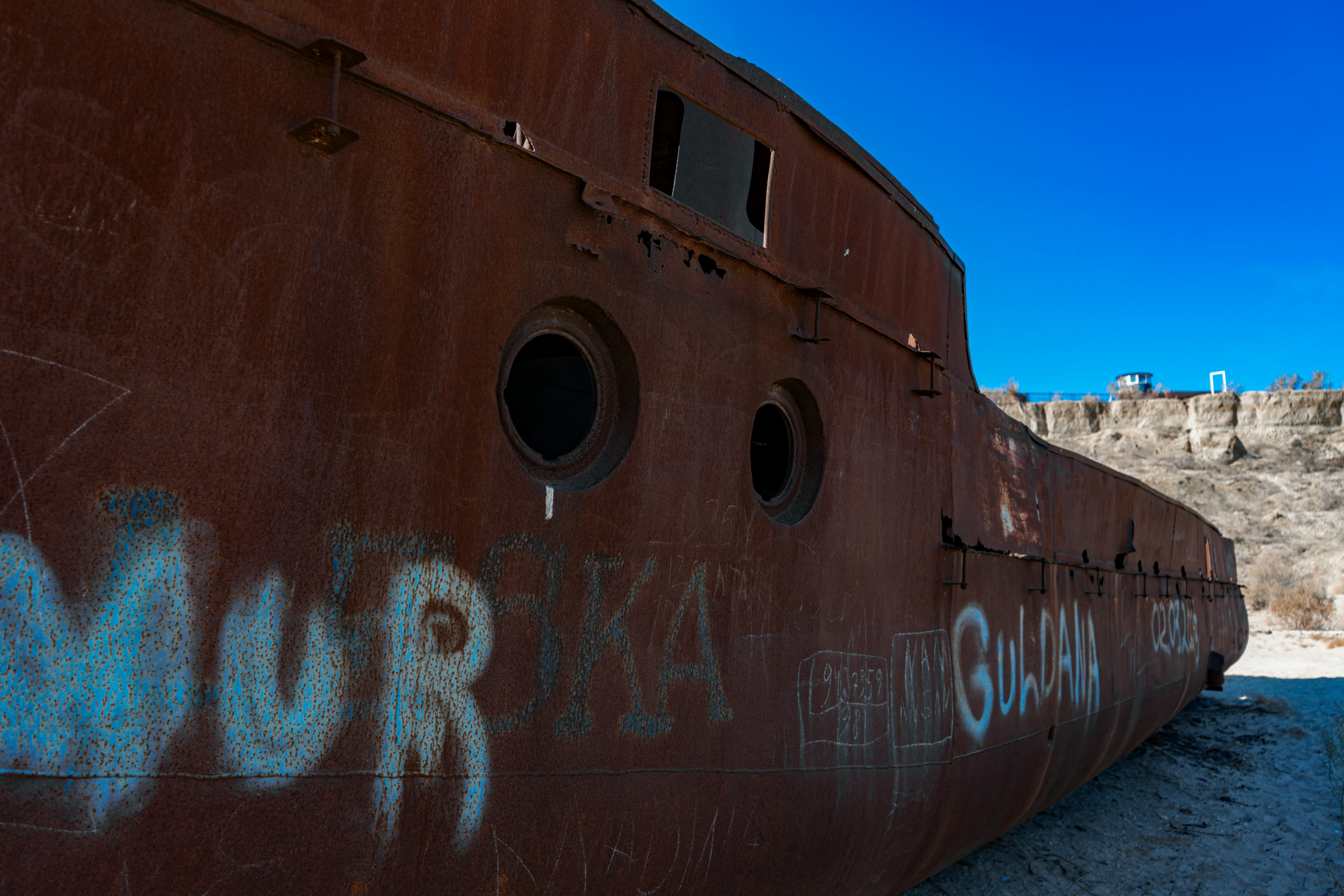 免費 在乾涸的鹹海地區，一艘廢棄的、鏽跡斑斑的船隻，體現了環境影響和船隻被遺棄的情況。 圖庫相片
