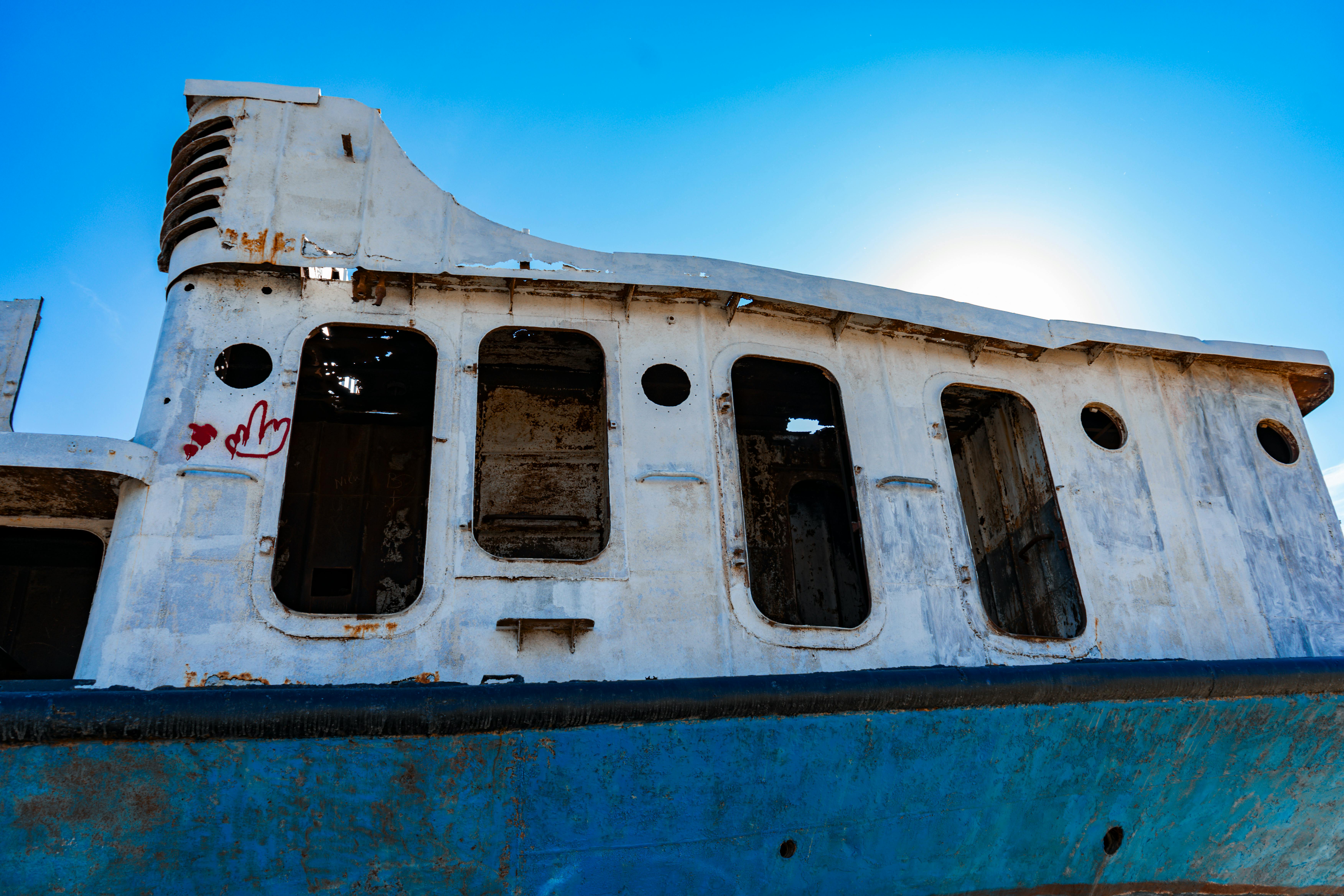免费 一艘锈迹斑斑的废弃船只静静地躺在咸海的蓝天下，象征着环境变化的影响。 素材图片