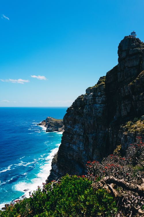 Free Breathtaking view of rocky cliffs by the ocean under a clear blue sky, capturing natural beauty. Stock Photo