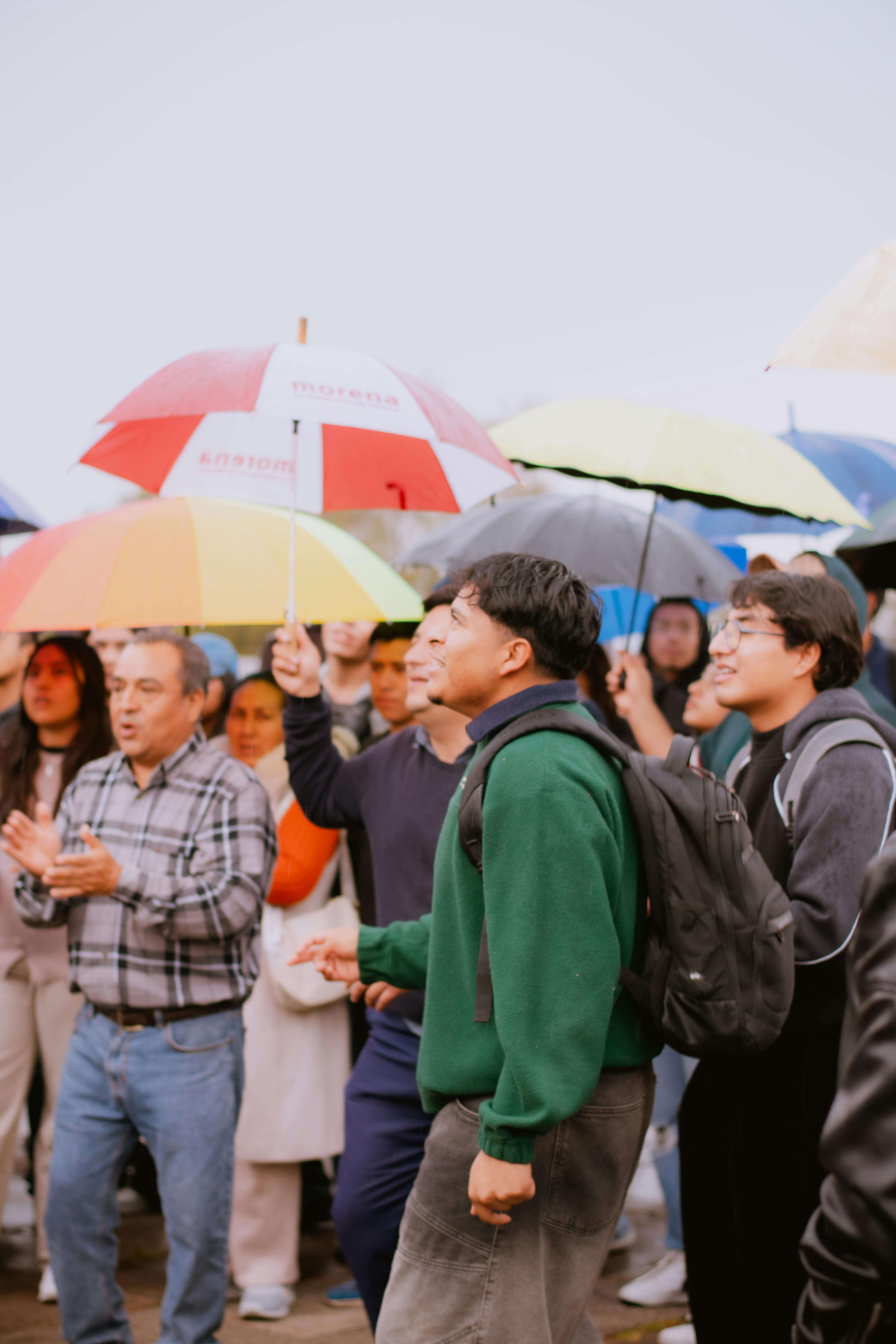 免费 雨天，一群形形色色的人们聚集在户外，撑着五颜六色的雨伞。 素材图片
