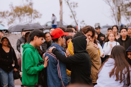 Free A group of people gather outdoors, offering comfort and support to one another. Stock Photo
