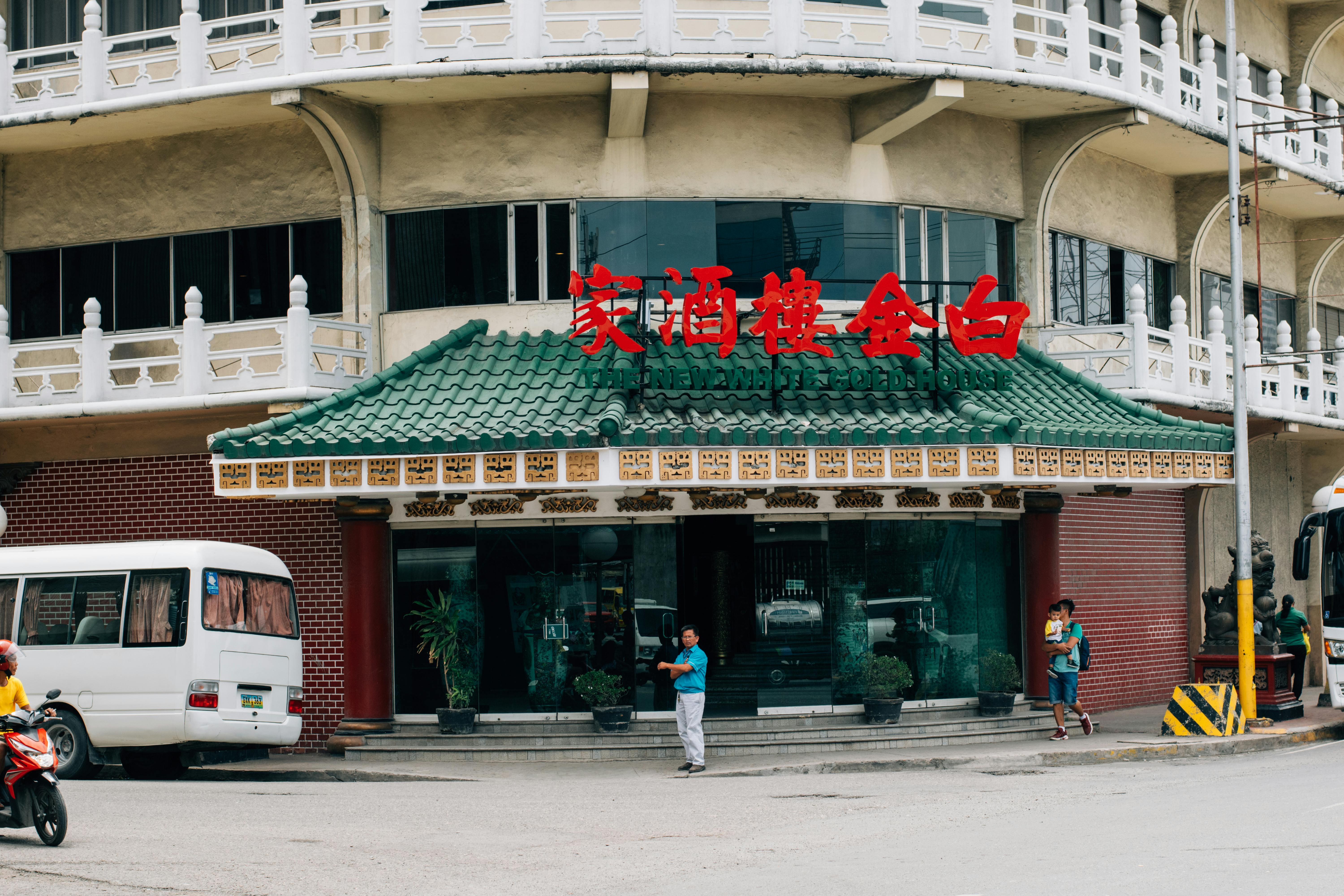 무료 녹색 지붕과 붉은색 간판이 있는 중국 식당의 거리 풍경으로, 도시의 일상을 담아내고 있다. 스톡 사진