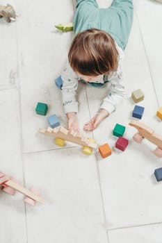 孩子们在浅色地板上玩着色彩缤纷的木制玩具，营造出有趣又富有教育意义的环境