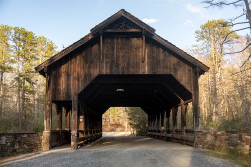 Free Historic covered bridge in Cedar Mountain, North Carolina surrounded by forest scenery. Stock Photo