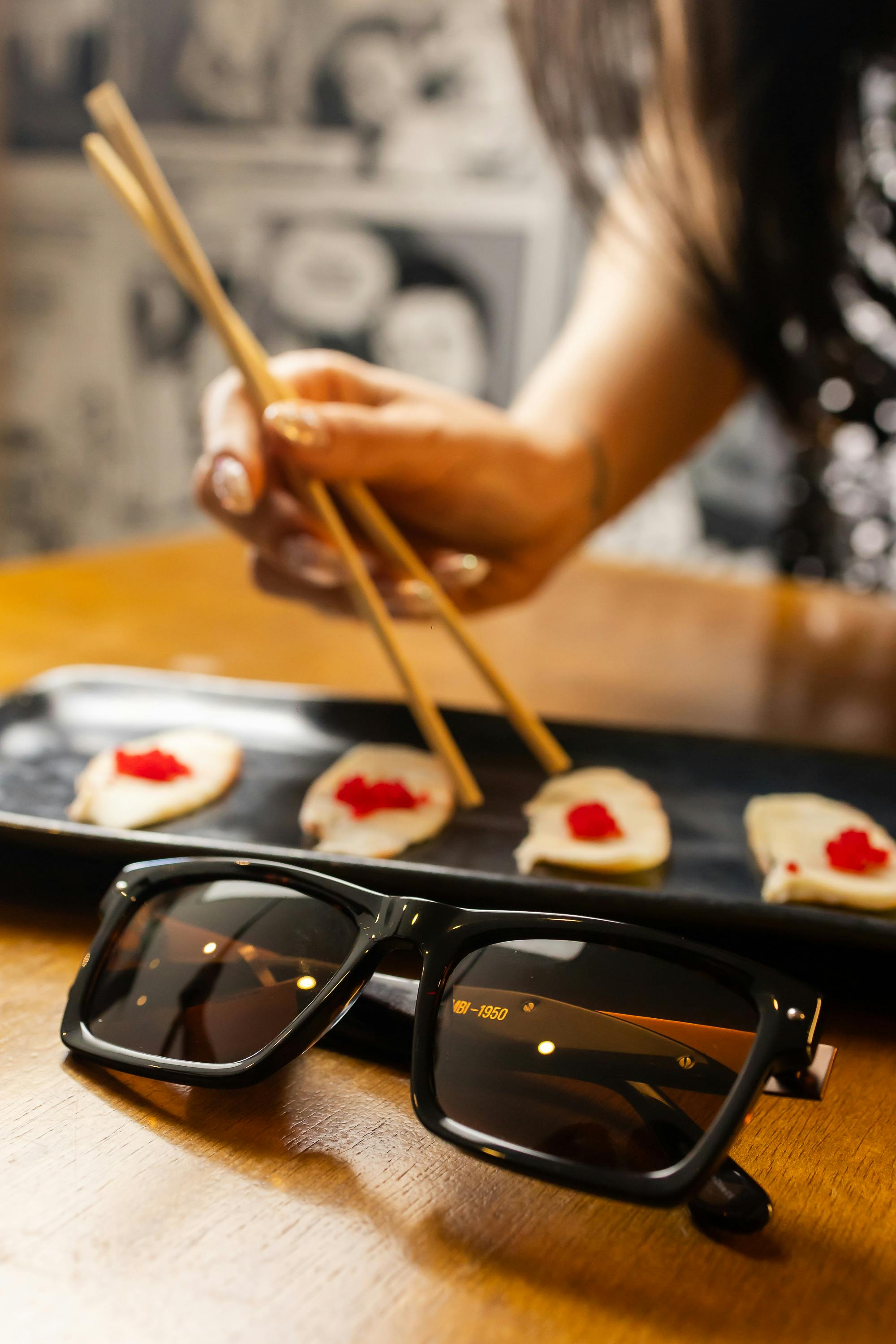免费 特写镜头：木桌上，寿司、筷子和太阳镜摆放在一起。 素材图片