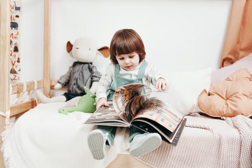 Free photo of a baby girl perusing a magazine Stock Photo
