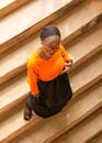 Woman in Bright Orange Top on Staircase from Above