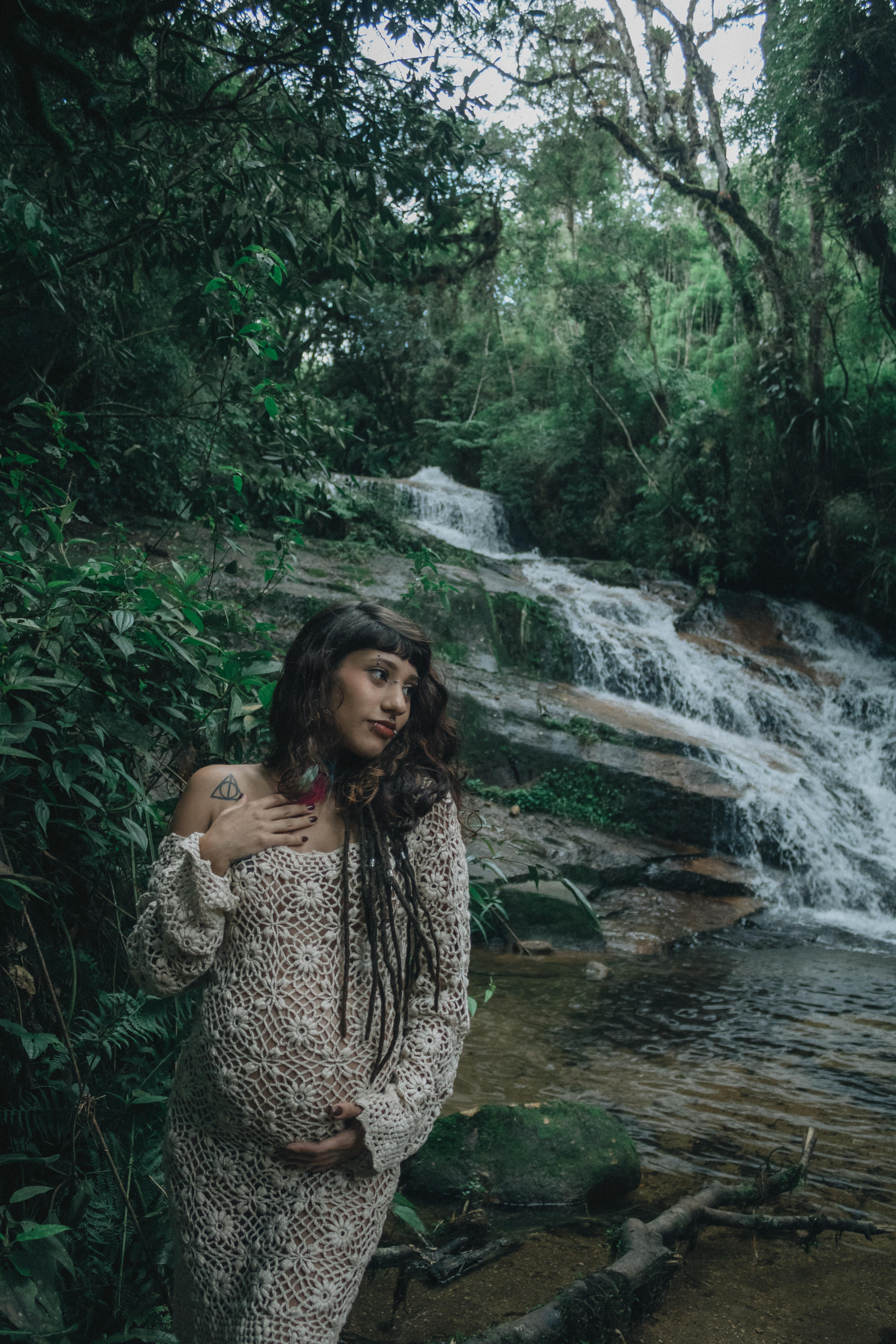 ฟรี หญิงตั้งครรภ์ในบรรยากาศธรรมชาติ โดยมีน้ำตกเป็นฉากหลัง แสดงถึงความสงบและความงดงามของธรรมชาติ คลังภาพถ่าย