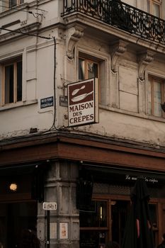 Charming street view of a crepe shop in Brussels, showcasing classic European architecture.