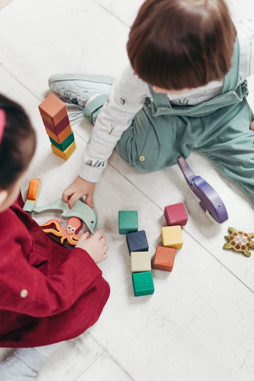 бесплатная двое детей играют с кубиками Lego и другими игрушками Стоковое фото