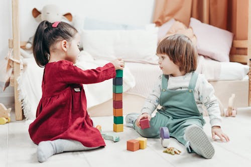 Free Children Sitting Down on the Floor Playing with Lego Blocks Stock Photo