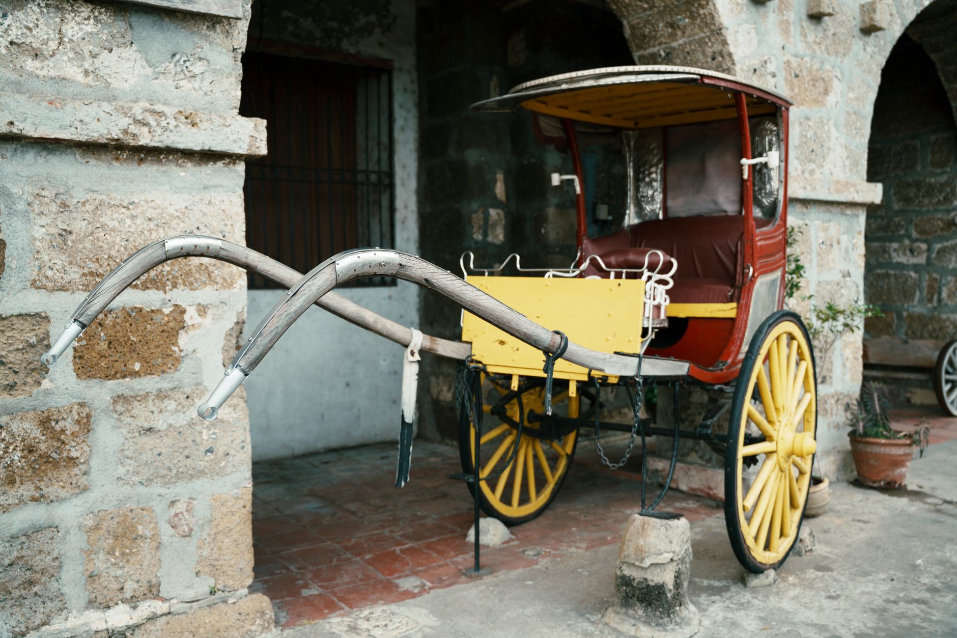 A traditional kalesa horse carriage set against the rustic stone architecture of Taal, Philippines.