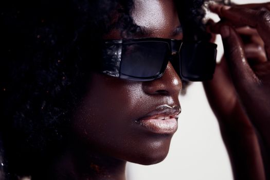 Close-up portrait of a stylish black woman wearing modern sunglasses, showcasing elegance and confidence.
