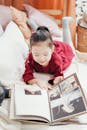 Girl in Red Dress Lying in Bed Reading Book
