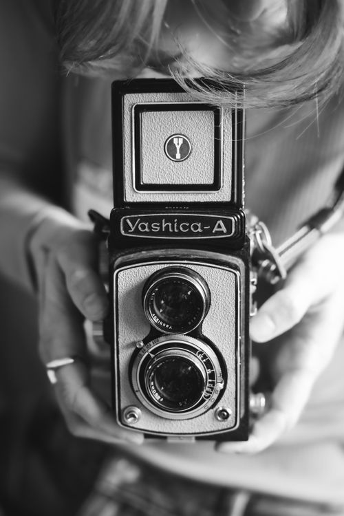 Free Black and white image of a Yashica camera held by an adult woman, captured in Chicago. Stock Photo