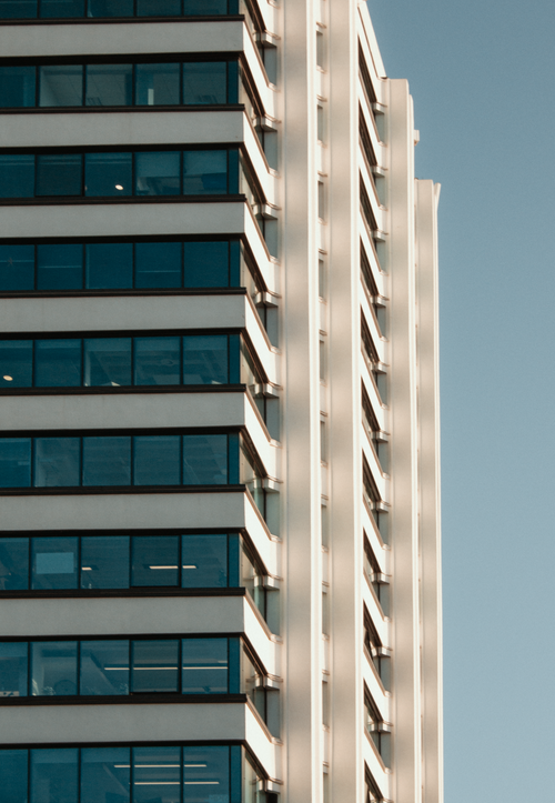 Free A contemporary skyscraper with glass windows reflecting blue sky, located in Manchester, England. Stock Photo