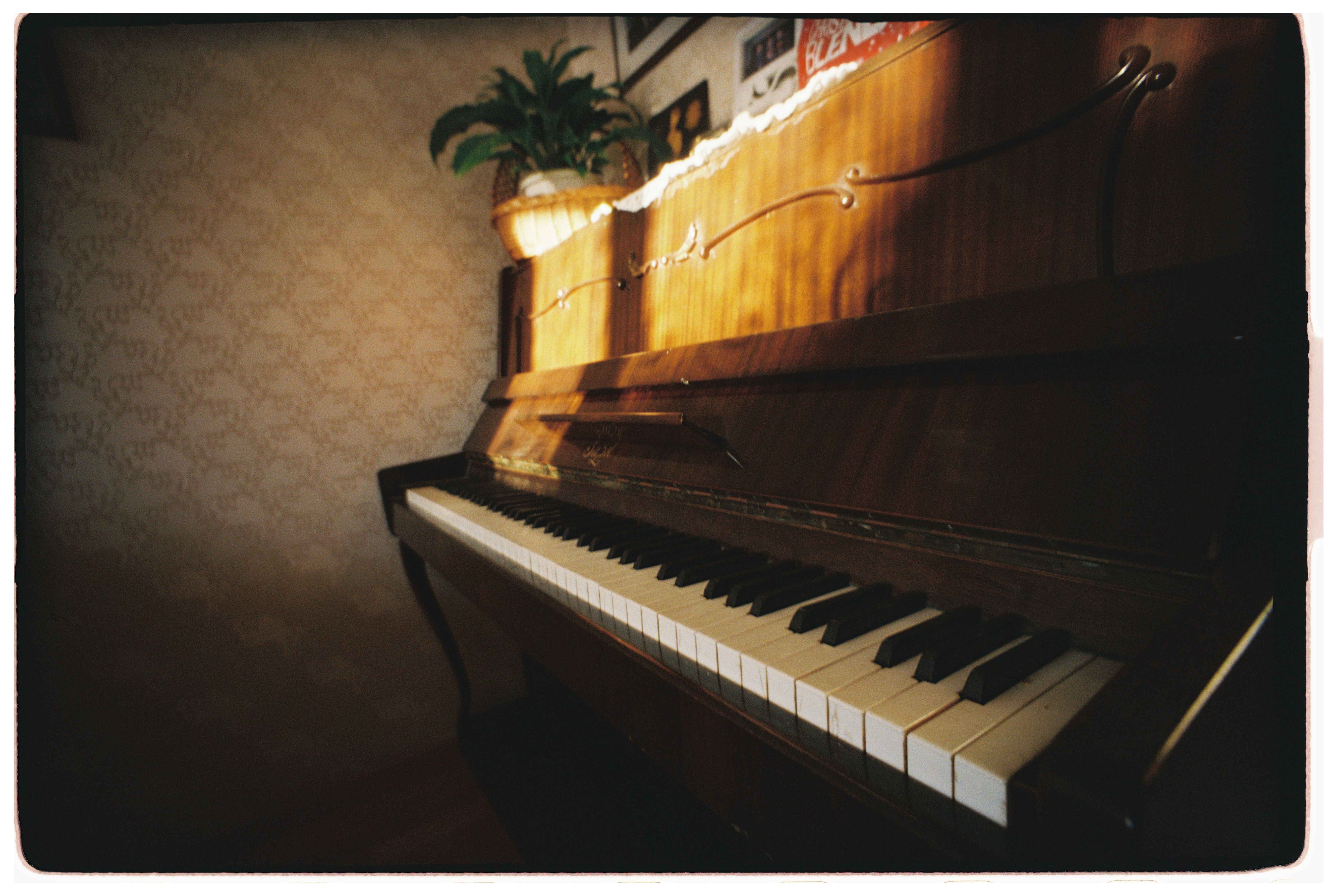 Warm sunlight illuminating a vintage upright piano in a serene, cozy room.