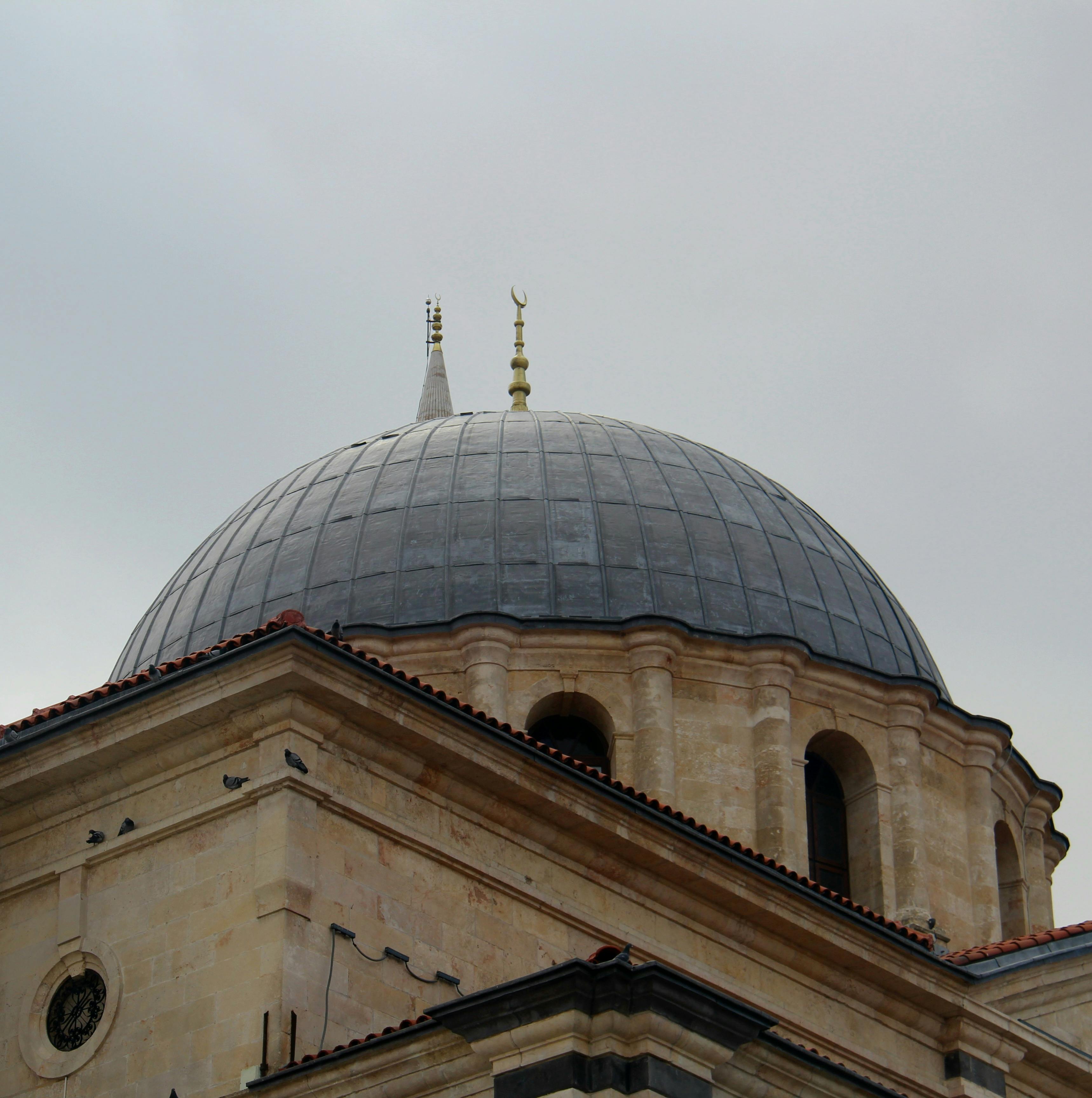 ingyenes Fedezze fel egy oszmán stílusú mecset kupolájának nagyszerűségét, bonyolult részletekkel borult ég alatt. Stockfotó