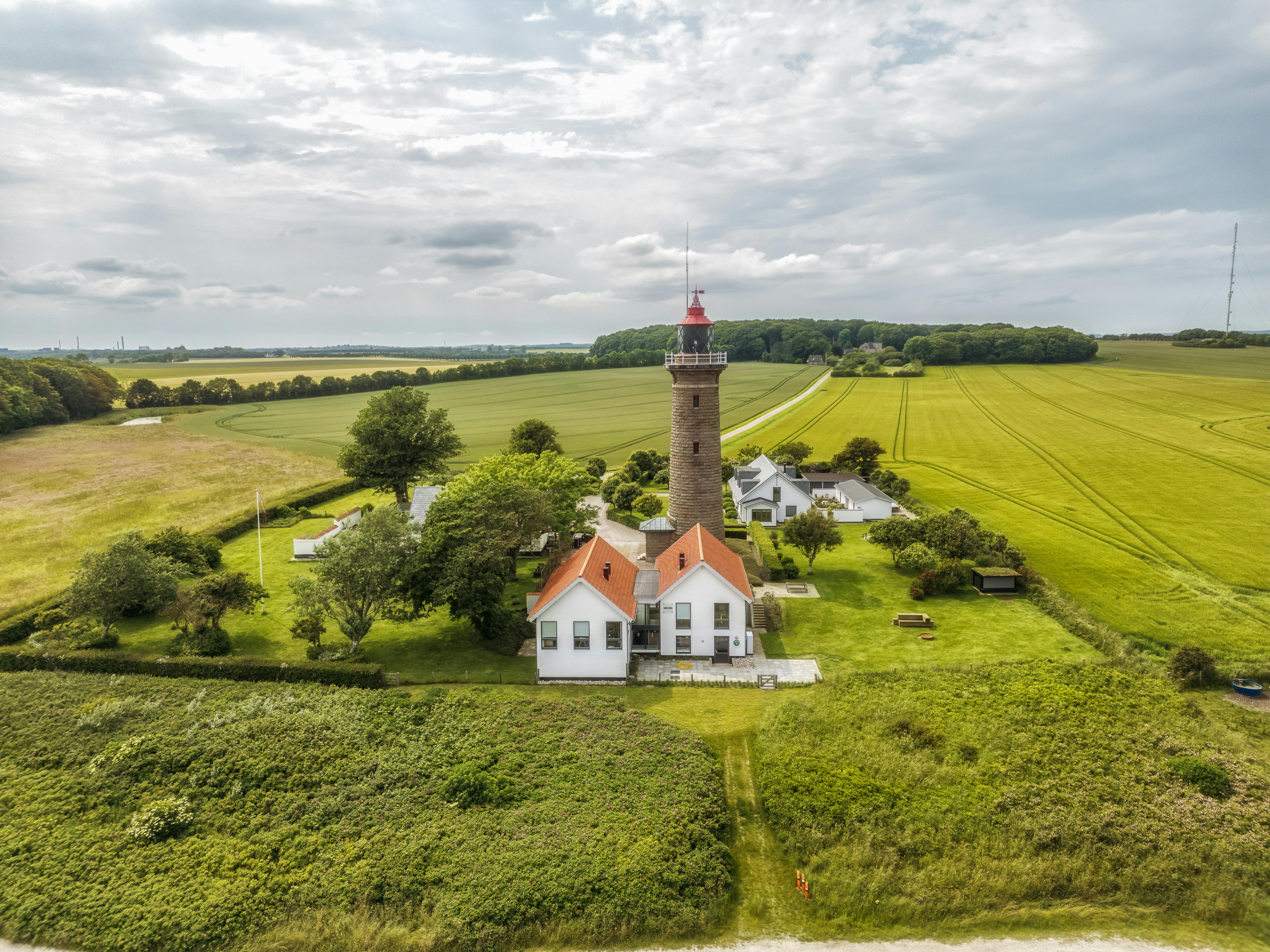 Zadarmo Letecký pohľad na maják Slettehage obklopený poľami so zamračenou oblohou. Fotka z fotobanky