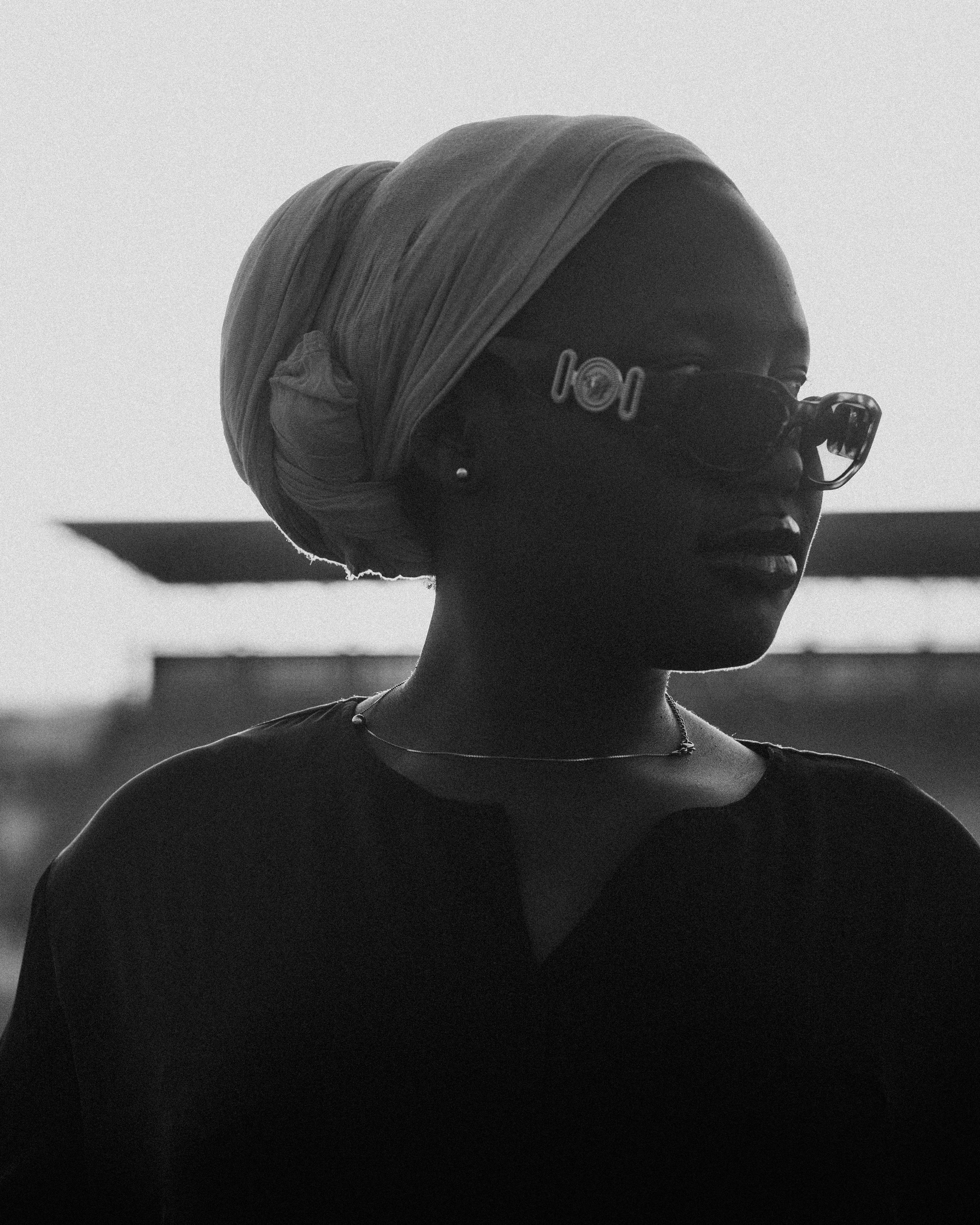 Zadarmo Elegantný monochromatický portrét ženy v slnečných okuliaroch, vyžarujúci šik a tajomnú auru. Fotka z fotobanky