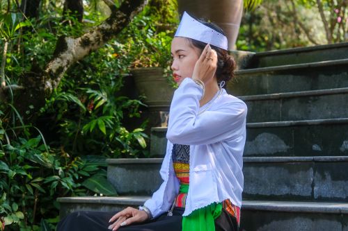 Free A woman in traditional Vietnamese attire sits outdoors in Hue, Vietnam. Stock Photo