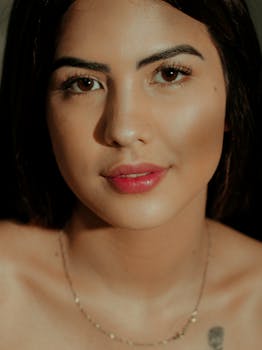 A striking close-up of a young woman with flawless skin and a confident smile.