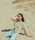 Woman Relaxing on Sandy Beach in Sunlight