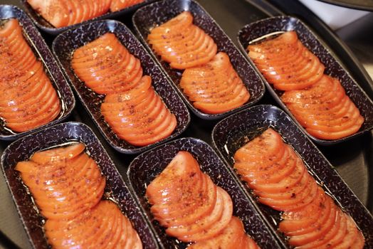 Sliced tomatoes seasoned and arranged in trays, perfect for cooking or presentation.