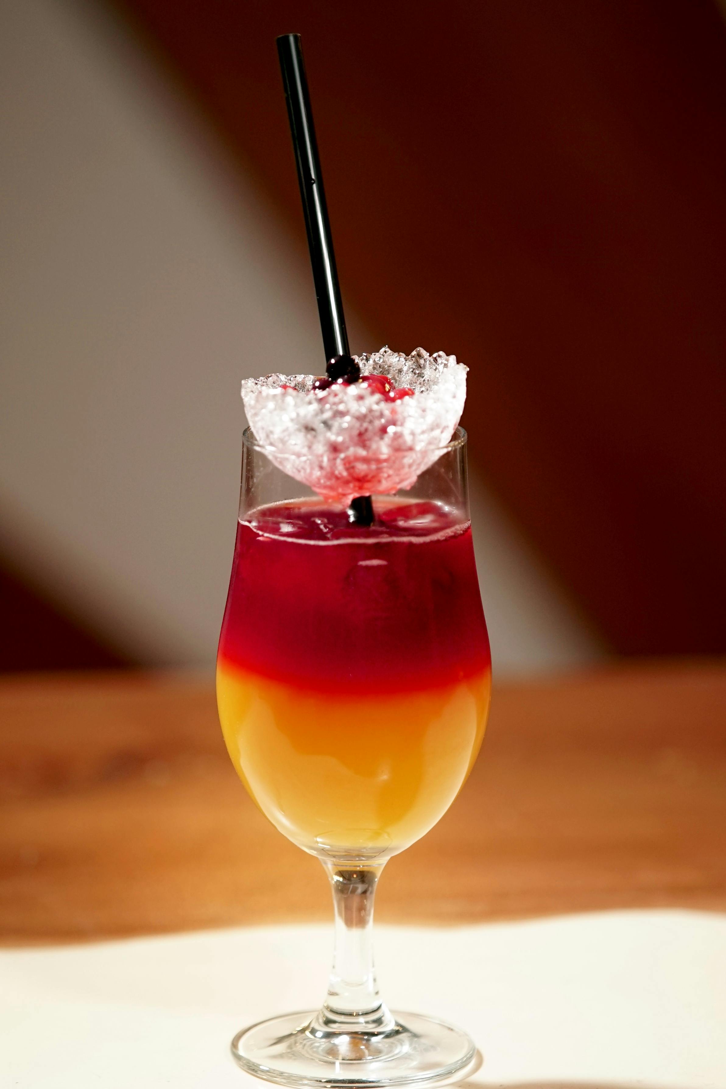 Zadarmo Farebný vrstvený kokteil s čerešňovou a slamkovou ozdobou v pohári. Fotka z fotobanky