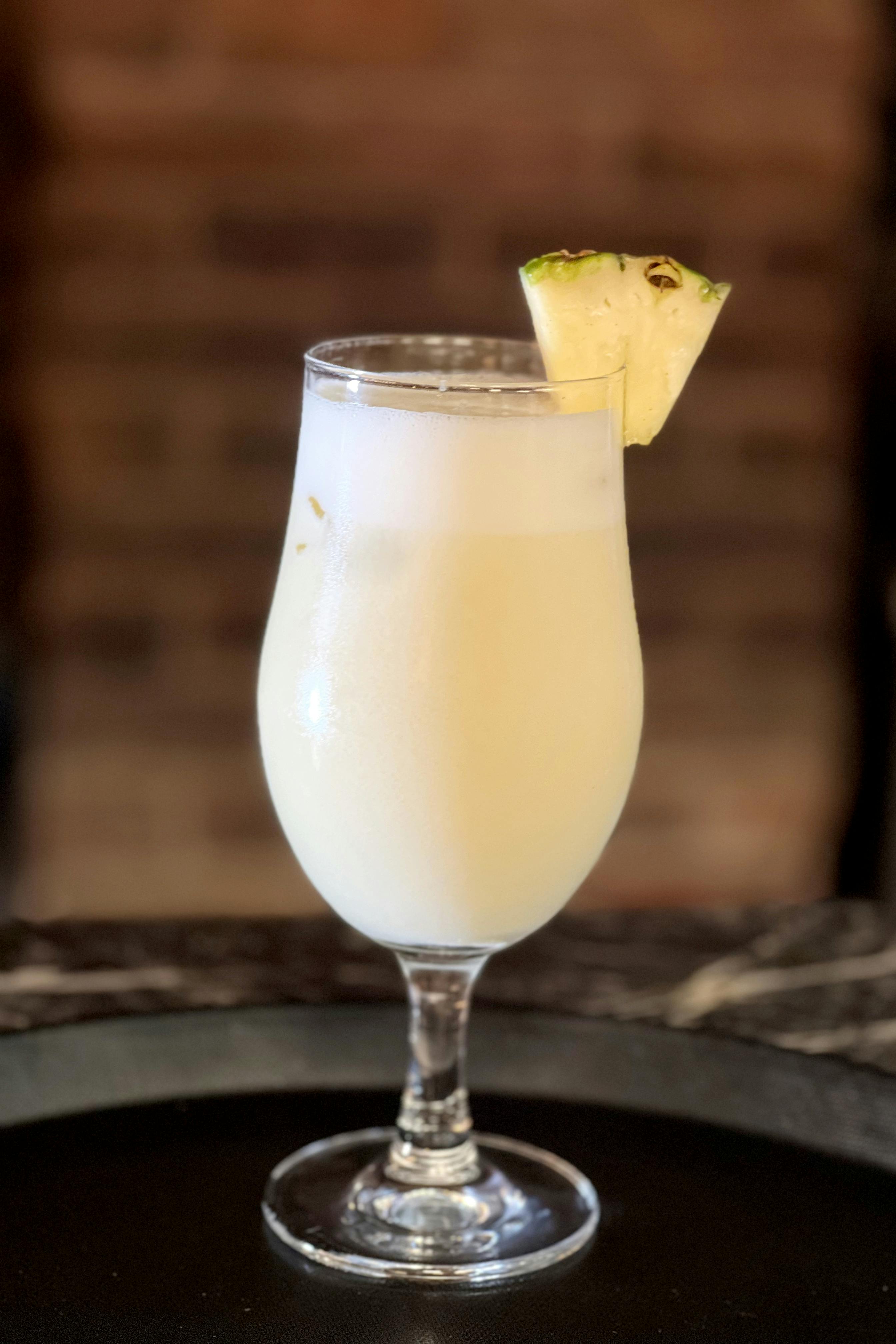 Zadarmo Chladená Piña Colada v pohári s ozdobou z čerstvého ananásu. Fotka z fotobanky