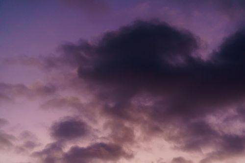 Free A striking view of dark clouds during sunset with a purple sky backdrop, creating a moody atmosphere. Stock Photo