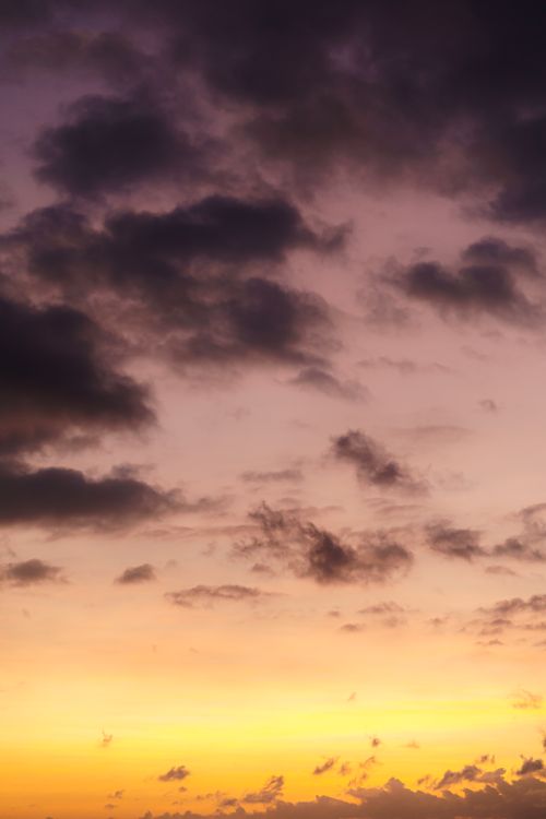 Free A vibrant and dramatic sunset with purple clouds and orange hues creating a stunning sky landscape. Stock Photo